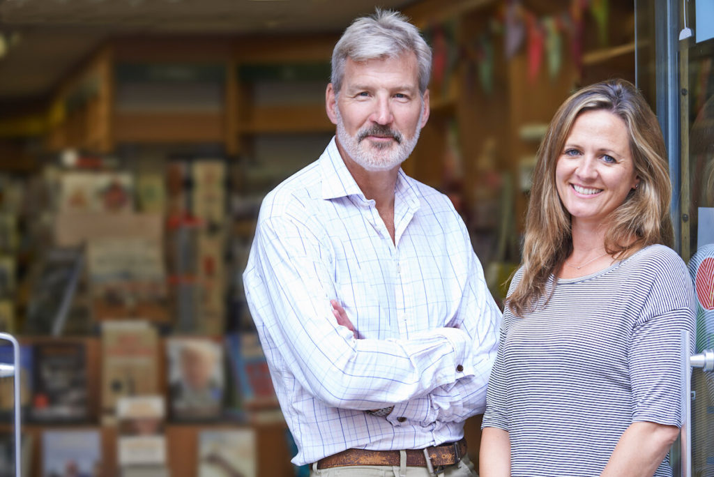 What is a strategic buyer: happy couple standing outside their store