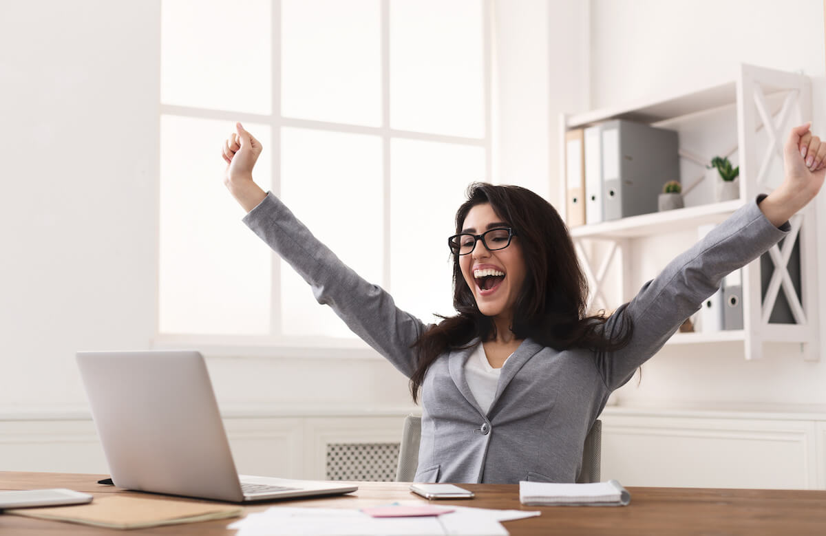 Small business owner retirement strategies: happy woman looking at her laptop